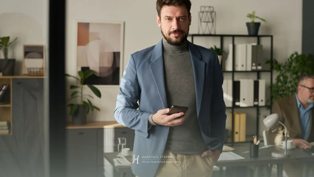 Professional man in office holding smartphone representing transition from corporate role to private PA environment