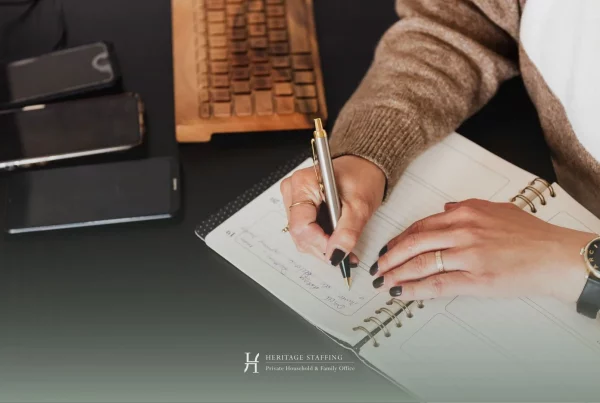 professional writing in planner with devices nearby, illustrating executive calendar management and time optimization strategies