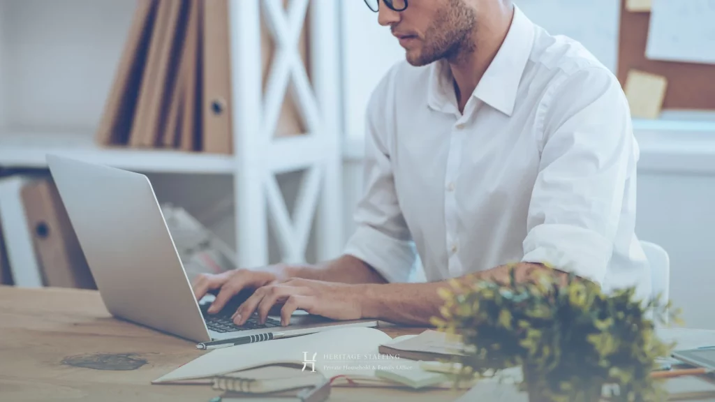 professional working on laptop with notebooks, representing reliance on manual knowledge in estate management operations