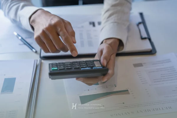 Close-up of hands using calculator over financial reports illustrating cost analysis for SFO vs MFO in Switzerland