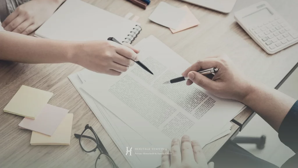 two professionals reviewing and signing documents, highlighting confidentiality protocols in private household recruitment