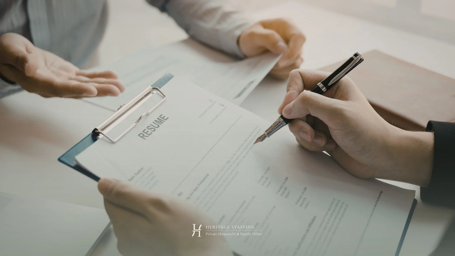 candidate signing resume during a professional interview, illustrating confidentiality protocols in external recruitment for private households