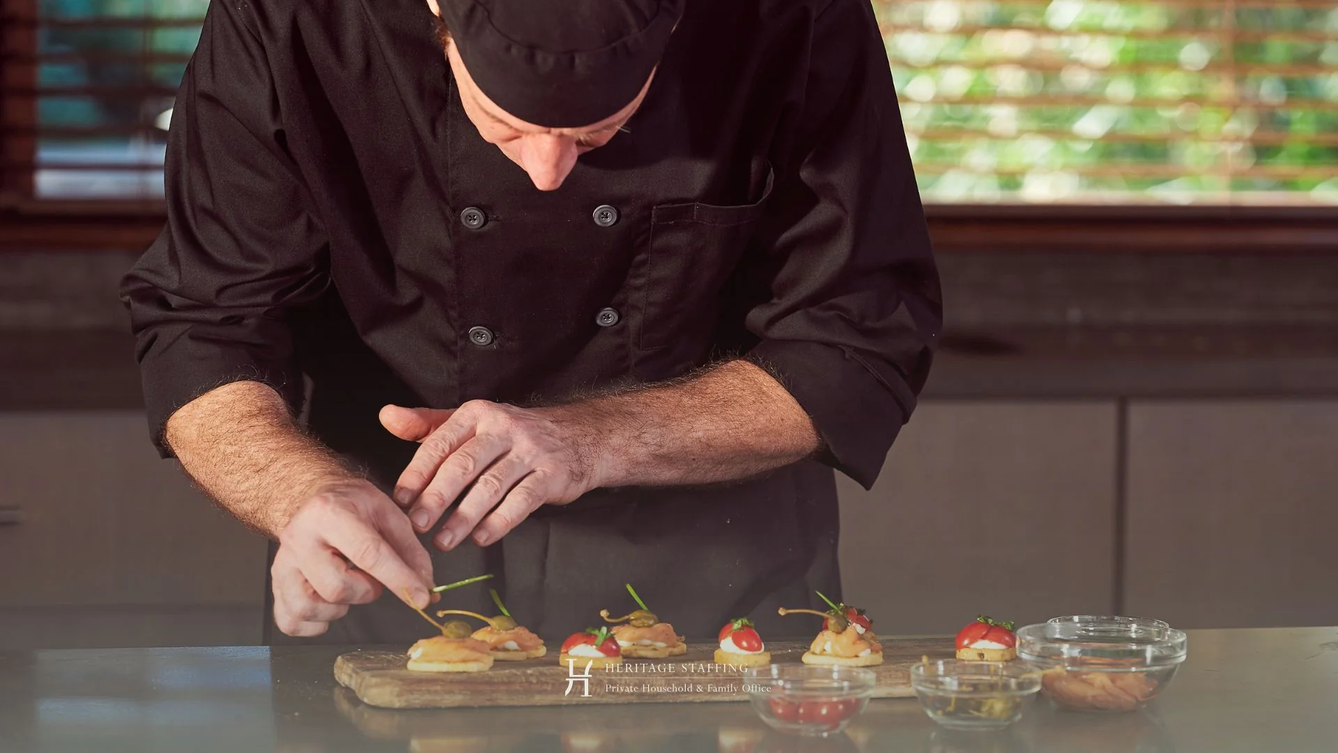 Private chef carefully plating gourmet canapés in a luxury residential kitchen, reflecting food safety liability management in family offices.