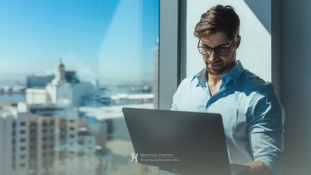estate manager reviewing property data on laptop in a high-rise setting, illustrating strategic oversight in private estates