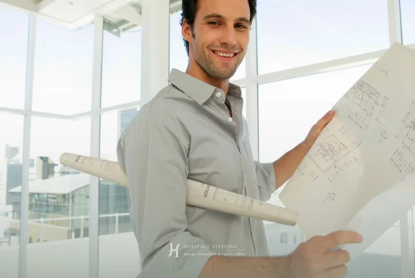professional property manager reviewing architectural plans in a modern estate setting, illustrating the difference between property manager and estate manager roles