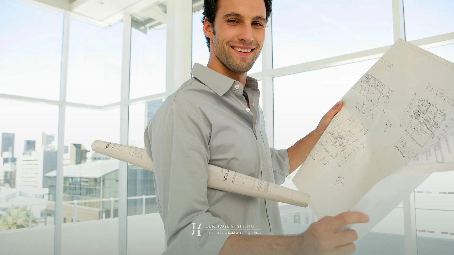 professional property manager reviewing architectural plans in a modern estate setting, illustrating the difference between property manager and estate manager roles